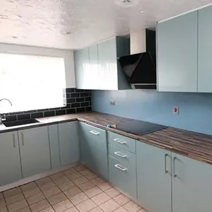 a kitchen with blue cabinets and tile flooring