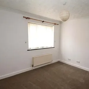 An empty room with a window and a radiator.