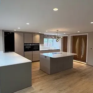 A kitchen with a center island next to a stove top oven.