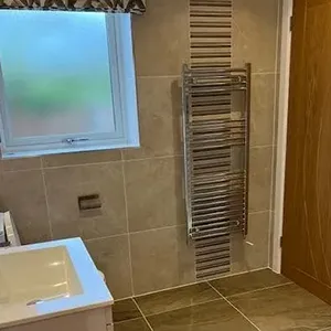 A bathroom with a toilet, sink and a radiator.