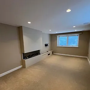 An empty room with a fireplace and a window.