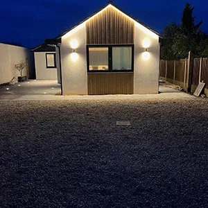 a small white house with lights on at night