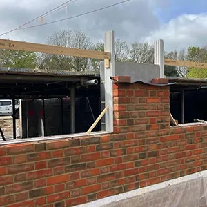 A brick wall with a fire hydrant on top of it.