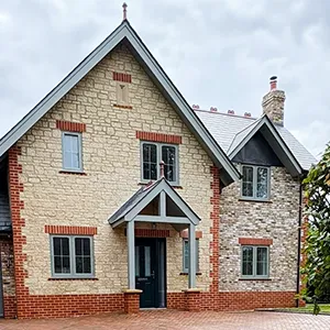 A brick house with a black door and windows.