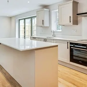 A kitchen with an island and a stove top oven.