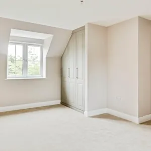 An empty room with white walls and a large window.