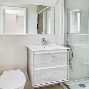 A bathroom with a toilet, sink, and shower.